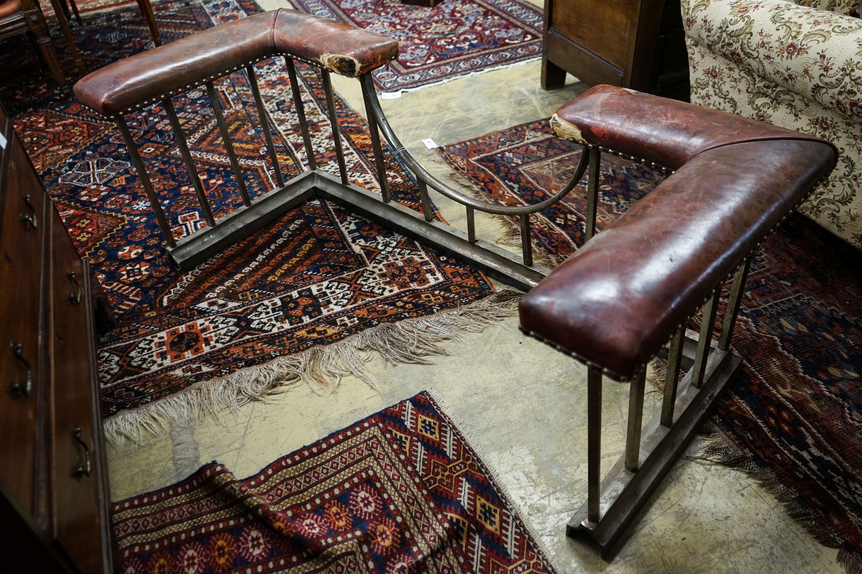 An early 20th century steel and burgundy leather club fender, length 140cm, depth 58cm, height 50cm